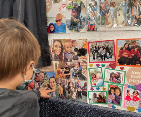 Child looking at a display of family photos.