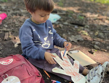 Child coloring outdoors.