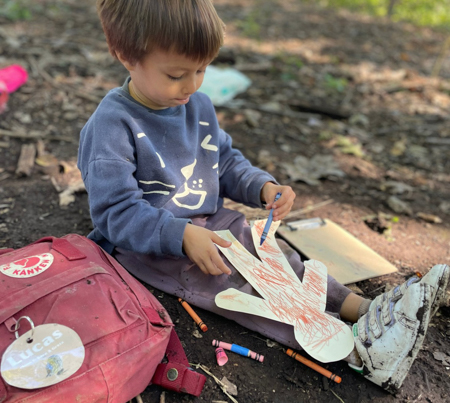 Child coloring outdoors.