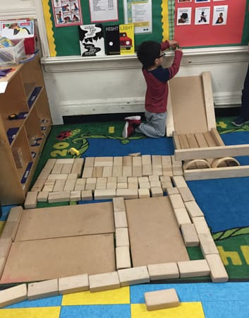 Child building with wood blocks.