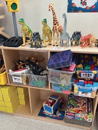 Shelf with accessory toys in bins.