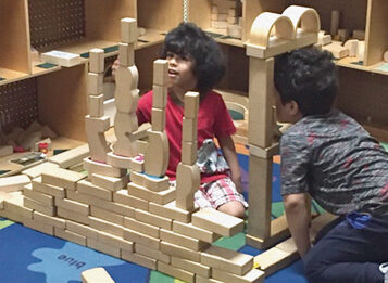 Two children stacking wooden blocks.