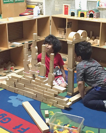 Two children stacking wooden blocks.