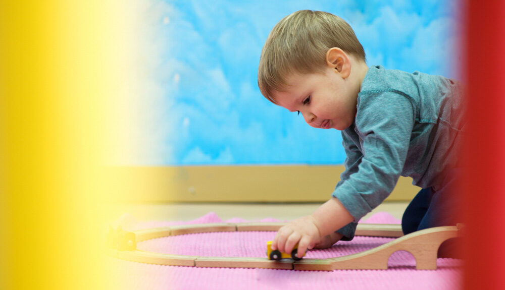 Child playing rail road toy