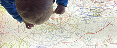 Child scribbling on a light table