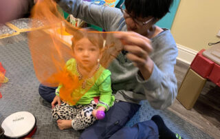 Woman and child play with see-through scarf