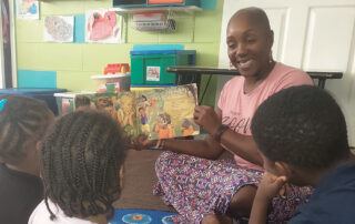 Woman reading picture book to children