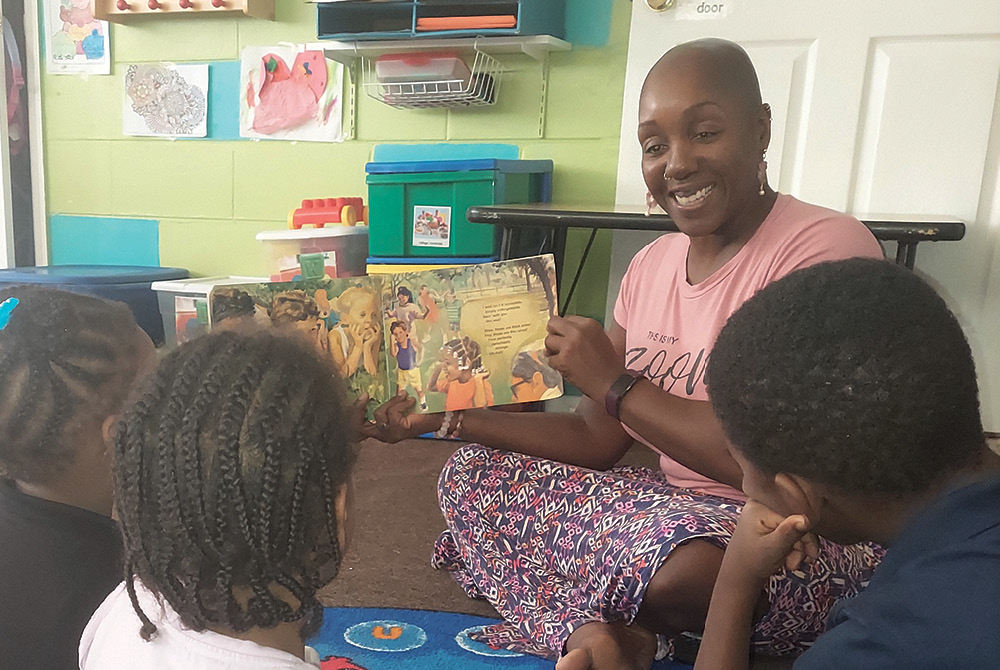 Woman reading picture book to children