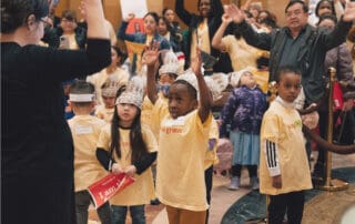 educator leads a group of children and adults in physical activity