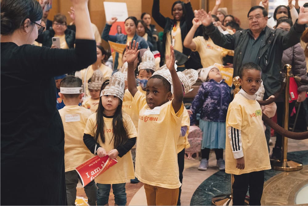 educator leads a group of children and adults in physical activity