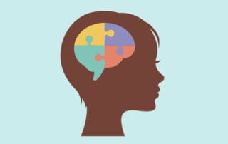 silhouette of child's head with connecting puzzle pieces that form a brain