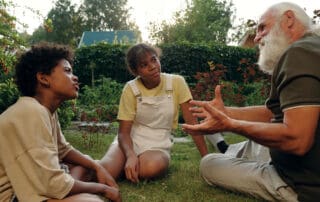 Elderly gentleman telling a story to two children