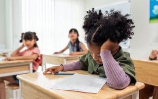Child sitting at a desk doing a worksheet