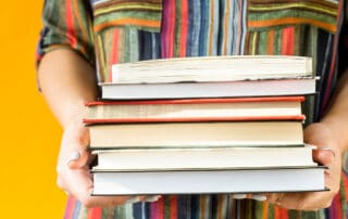 Adult holding a stack of books