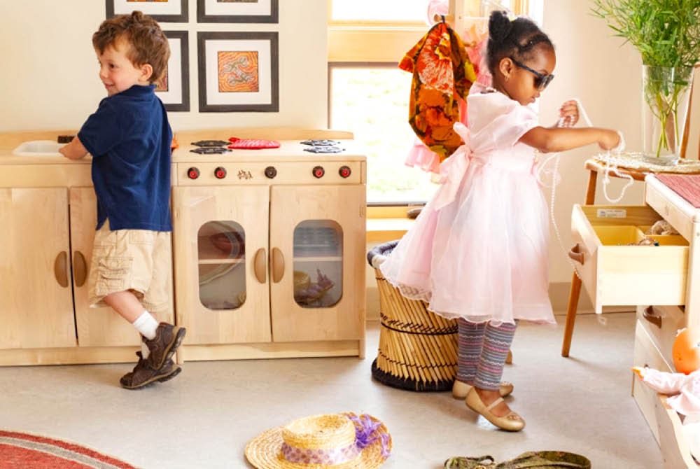 Children exploring a play kitchen