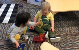 two children playing with blocks on floor