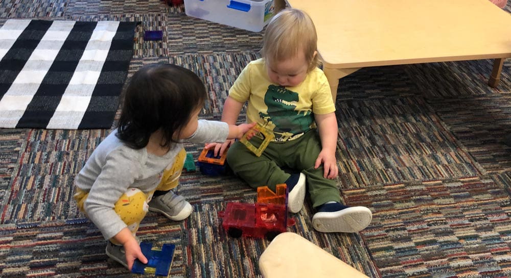 two children playing with blocks on floor