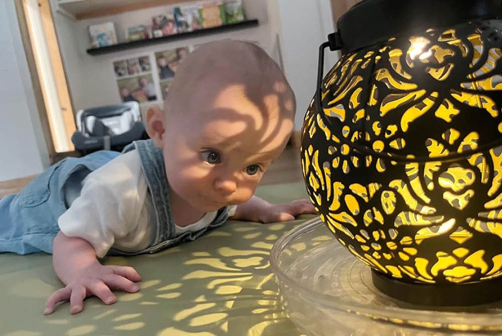 Infant looking at a glowing lantern