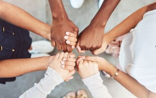 close-up of hands reaching out to support one another