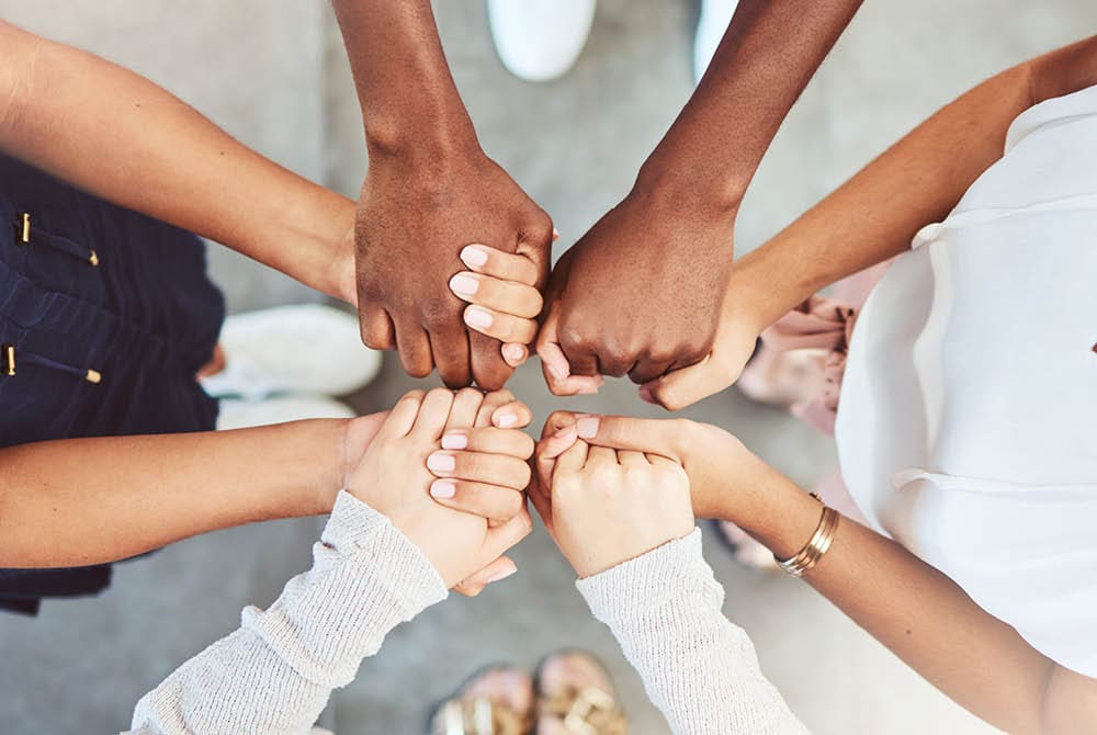 close-up of hands reaching out to support one another