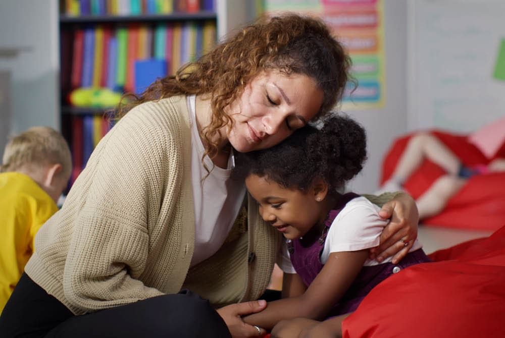 Educator comforts a child