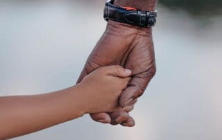 Grandfather holding the hand of a young child