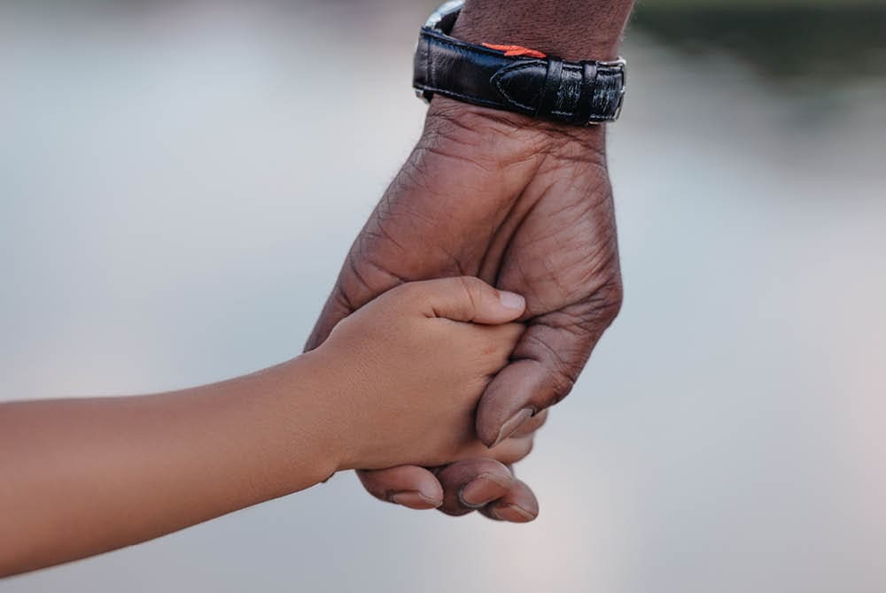 Grandfather holding the hand of a young child